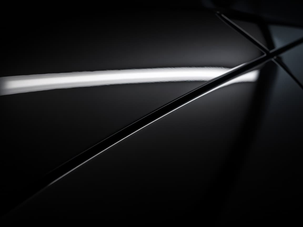 Machine polisher revealing gloss across corrected dark paint